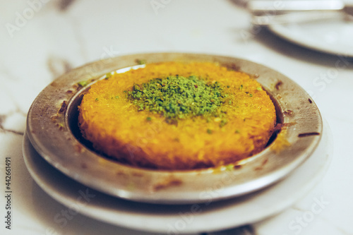Fresh delicious Turkish dessert Kunefe with pistachio powder photo