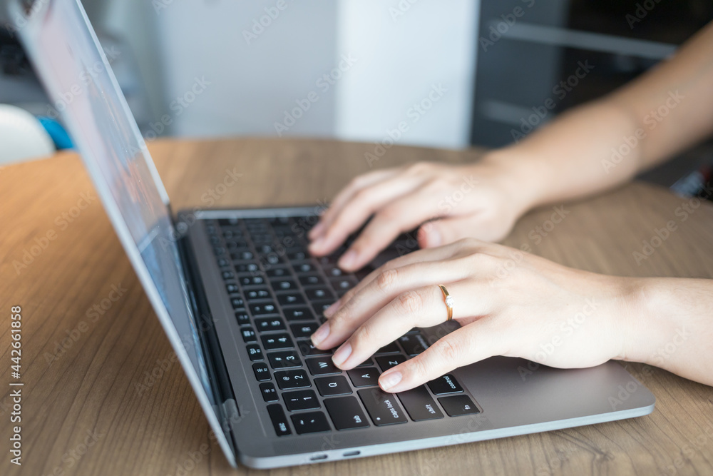 Working from home on laptop while typing chat to customer communicates on internet in home office Working from home on laptop while typing chat to customer communicates on internet in home office