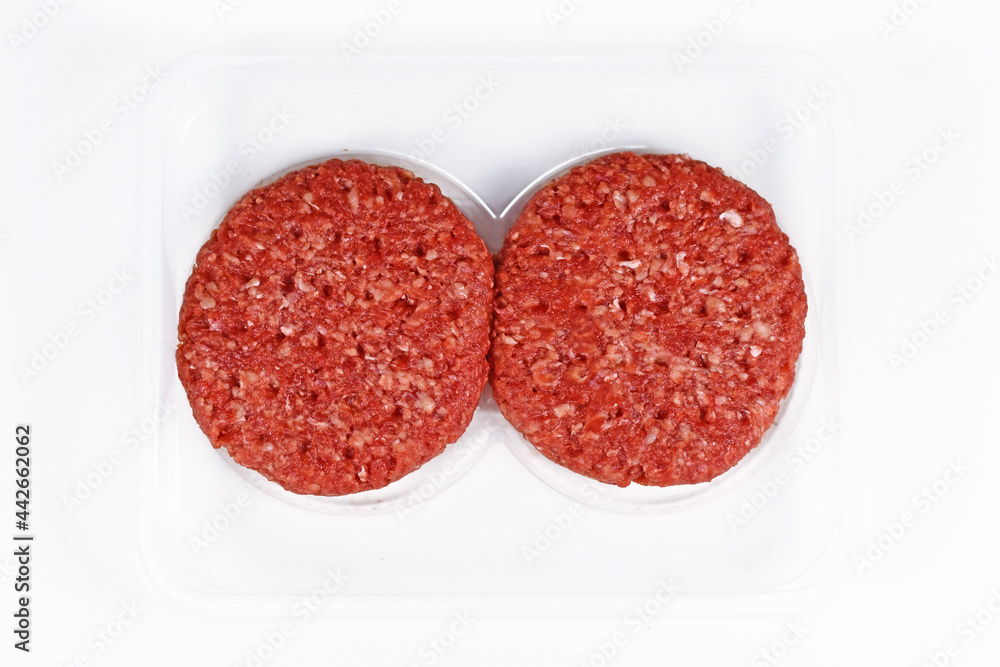 Two raw round burger patties in package on white background Two raw round burger patties in package on white background