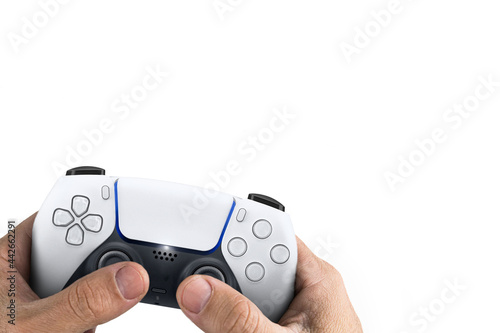 Male hand holding a Next Generation white game controller isolated on white background.