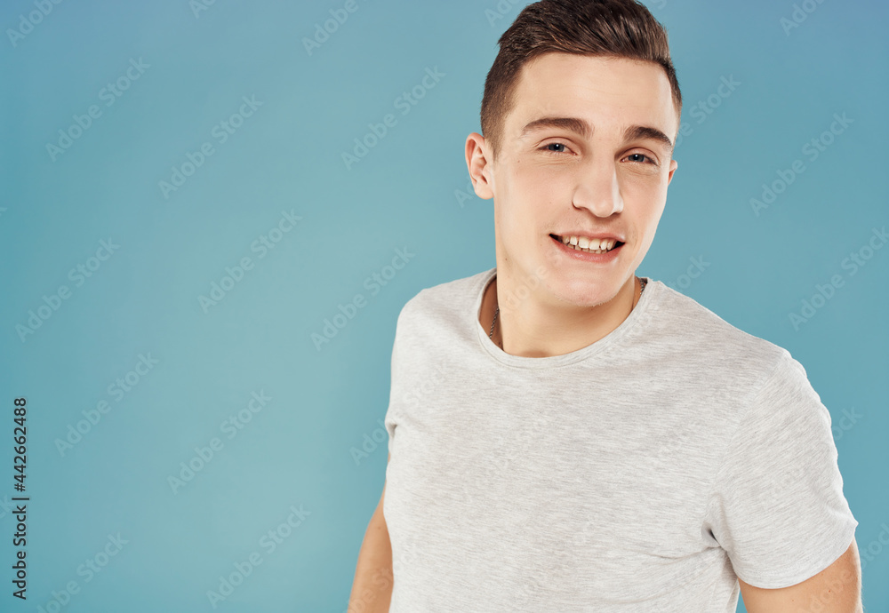 Cheerful handsome man in T-shirt on a blue background emotions Cheerful handsome man in T-shirt on a blue background emotions