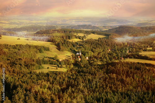 View from Szczeliniec Wielki in Stołowe Mountains to small, historic village of Pasterka. Poland. View of Czech side of Table Mountains by sunrise. photo