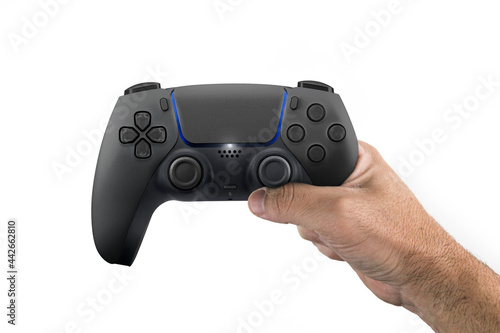 Male hand holding a Next Generation black game controller isolated on white background.