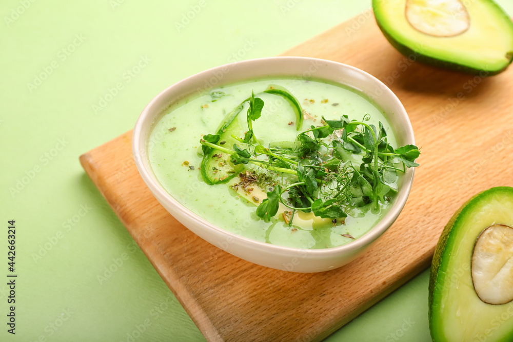 Board with green gazpacho and avocado on color background Board with green gazpacho and avocado on color background