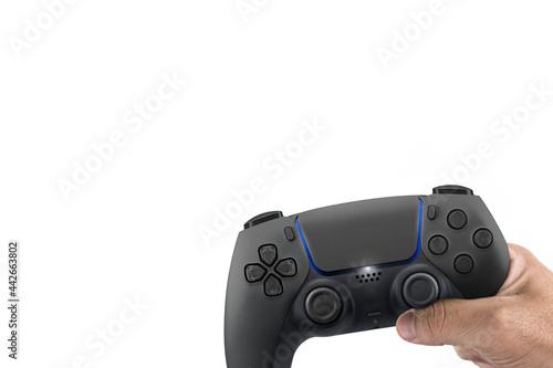 Male hand holding a Next Generation black game controller isolated on white background.