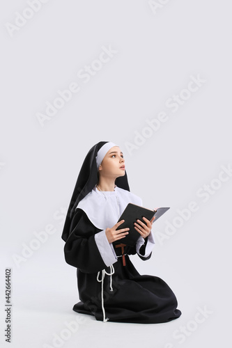 Young praying nun with Bibl...