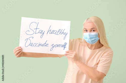 Senior woman holding poster...