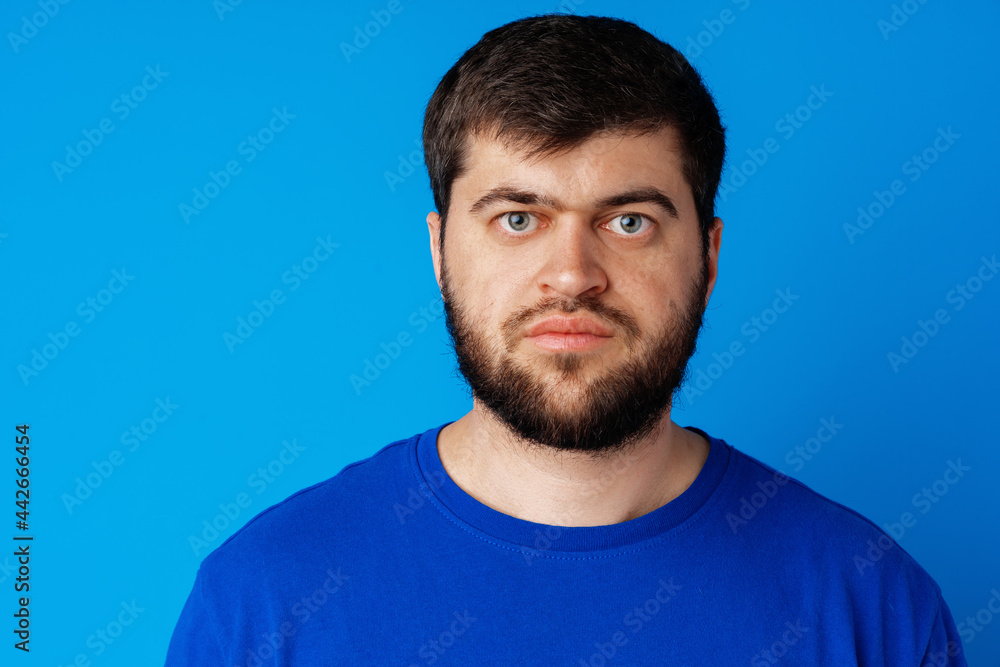 Fototapeta premium Close up portrait of caucasian bearded man on blue background