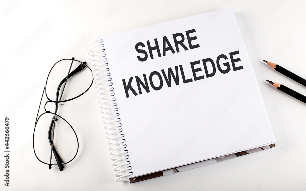 Notepad with text SHARE KNOWLEDGE White background. Business concept
