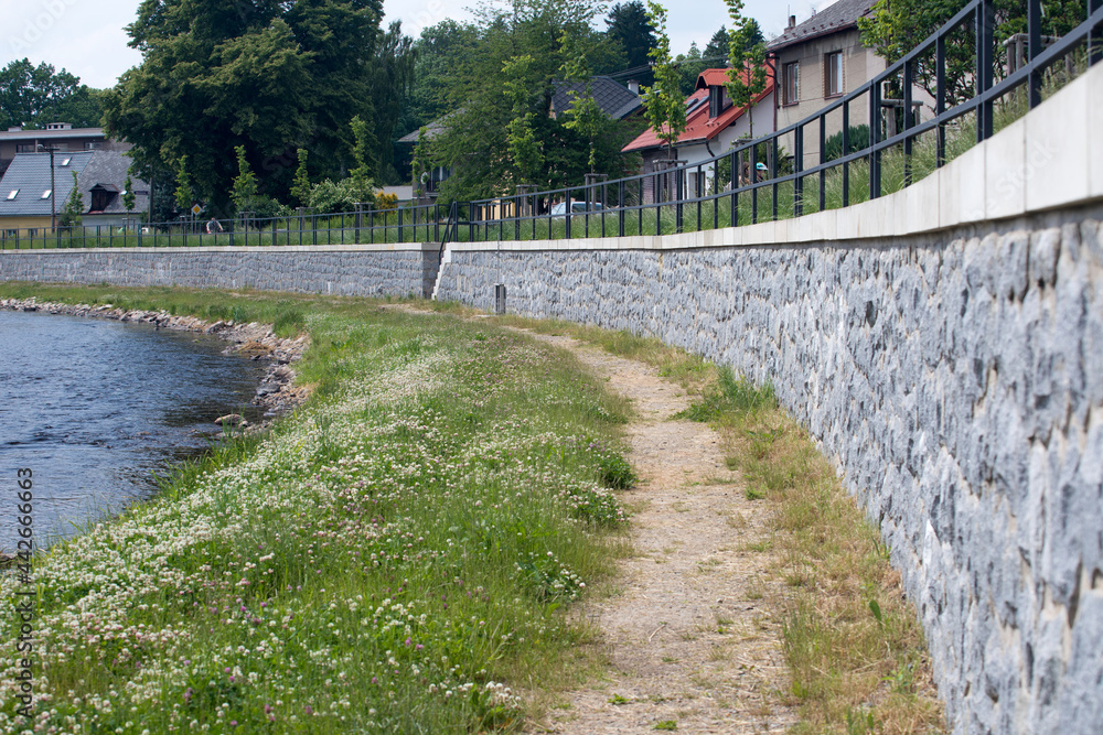 Modern flood protection wall in the style of the historic city wall. Permanent measures against floods. Dikes, gate valves, gates and walls. 
Flood gates protecting city against flooding from stream.