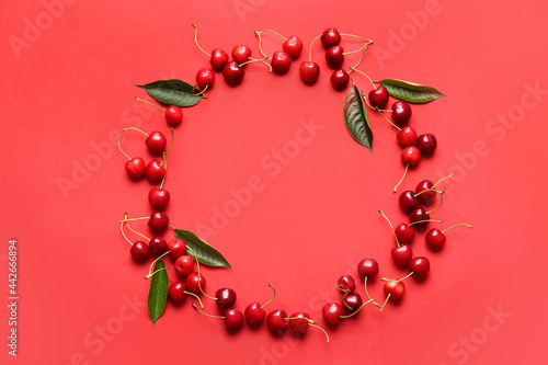 Frame made of tasty ripe cherry on color background