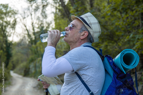 tired mountaineer man taking a drink break