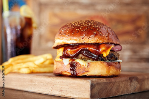 Delicious homemade hamburger or beef burger on wooden tray with cola and fires.