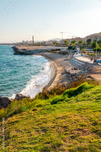 Montgat beach picture captured from a high point of view during golden hour. Mountains near the beach. Summer vibes. photo