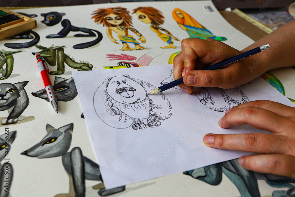 The animator draws with a pencil and draws characters from cartoons, comics or puppet shows. Mowgli's play. Preparing to make a doll. The designer creates sketches. Comics, cartoons, puppet theater Stock Photo | The animator draws with a pencil and draws characters from cartoons, comics or puppet shows. Mowgli's play. Preparing to make a doll. The designer creates sketches. Comics, cartoons, puppet theater Stock Photo |