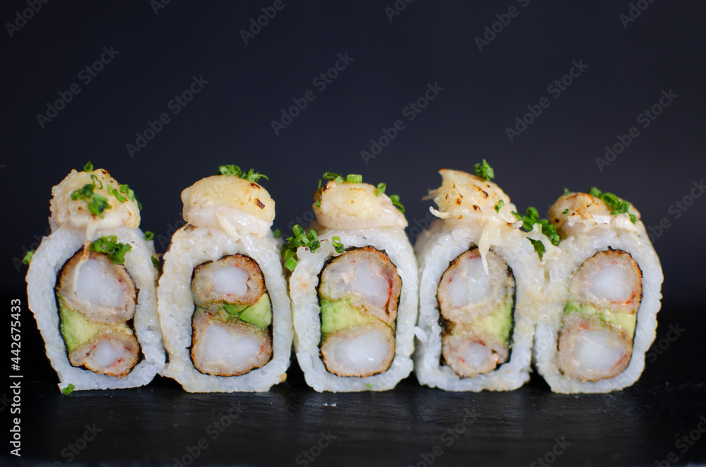 front view of shrimp and avocado sushi with scallops and chives topping front view of shrimp and avocado sushi with scallops and chives topping