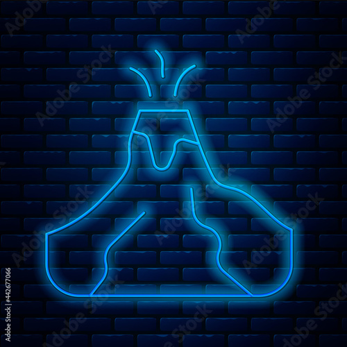 Glowing neon line Volcano eruption with lava icon isolated on brick wall background. Vector