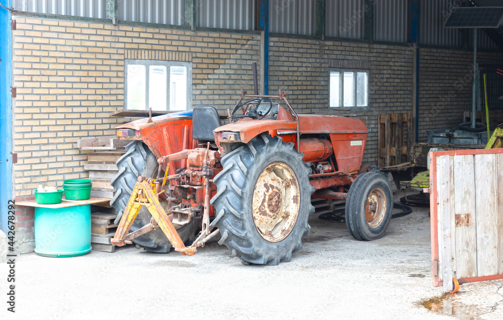 Obraz premium Old red tractor inside garage