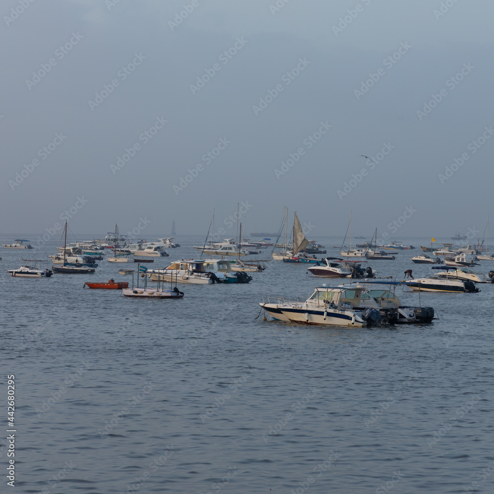 Boats and ferries anchored close to each other at Gate Way of India at Mumbai Maharashtra India during early morning hours on 2 April 2021