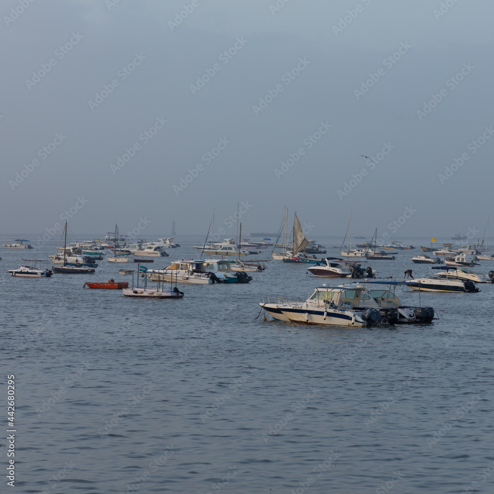 Boats and ferries anchored close to each other at Gate Way of India at Mumbai Maharashtra India during early morning hours on 2 April 2021 Boats and ferries anchored close to each other at Gate Way of India at Mumbai Maharashtra India during early morning hours on 2 April 2021