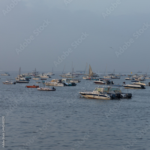 Boats and ferries anchored close to each other at Gate Way of India at Mumbai Maharashtra India during early morning hours on 2 April 2021