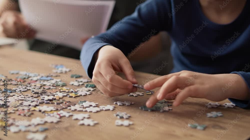 Video of son solving jigsaw puzzle during father working at home. Shot with RED helium camera in 8K. Video of son solving jigsaw puzzle during father working at home. Shot with RED helium camera in 8K.