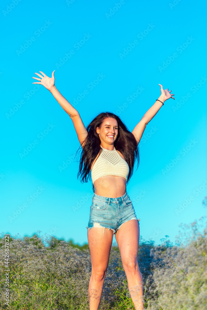 Woman raise hands up on blue sky background. Freedom feel good and travel adventure vacation concept.Toned. Woman raise hands up on blue sky background. Freedom feel good and travel adventure vacation concept.Toned.
