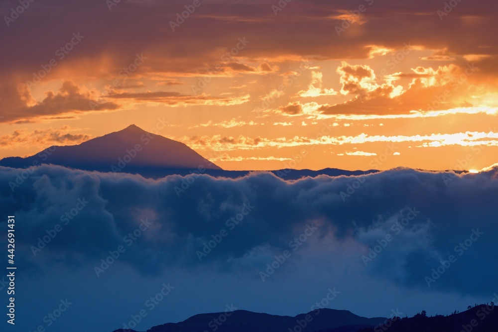 Volcano Pico del Teide rising from the clouds within sunset. Tenerife Canary Islands, Spain
