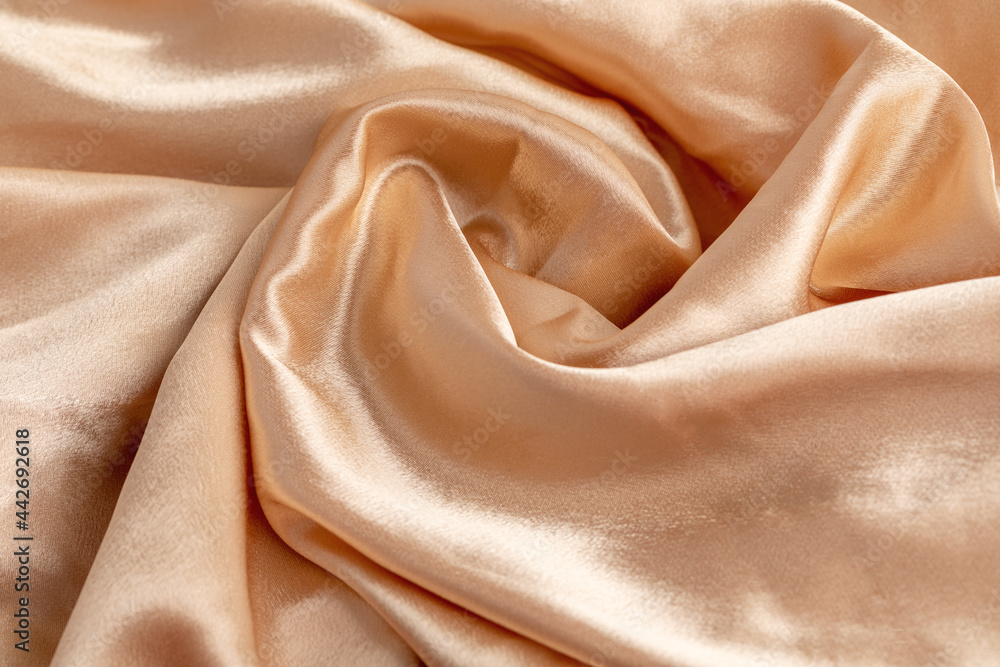 texture of golden silk fabric with a curl of folds, background, copy space texture of golden silk fabric with a curl of folds, background, copy space