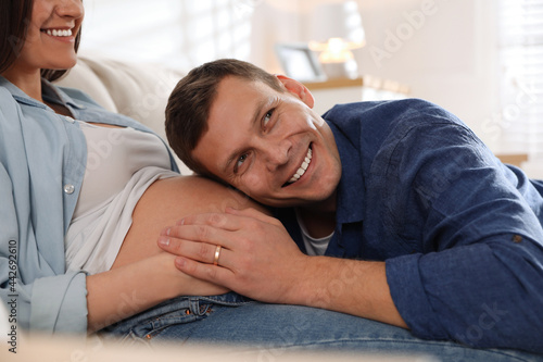 Young pregnant woman with her husband indoors, closeup