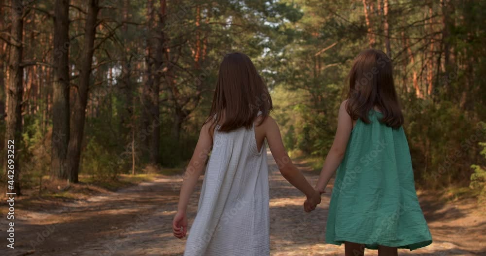 Two beautiful girls walking in the woods