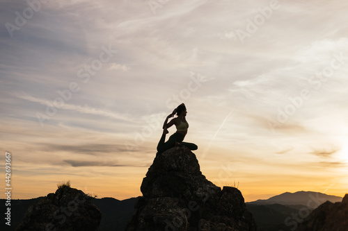 Unrecognizable woman enjoying yoga on rocky formations photo
