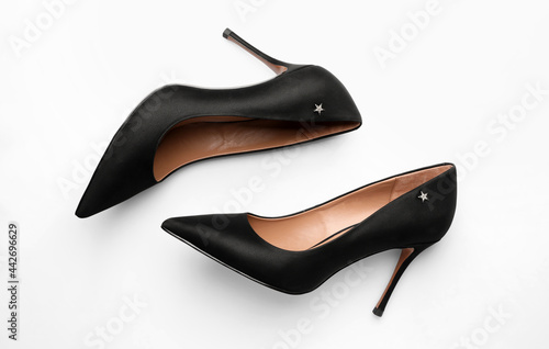 Pair of elegant black high heel shoes on white background, top view