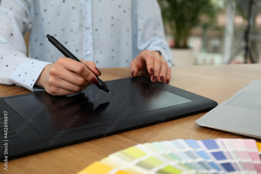 Professional designer with graphic tablet at wooden table, closeup Professional designer with graphic tablet at wooden table, closeup
