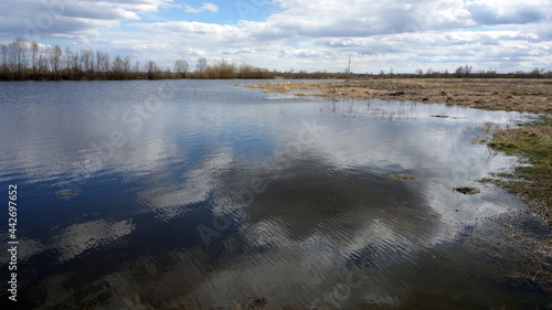 The clouds are reflected in the lake. Spring Siberian landscape. 