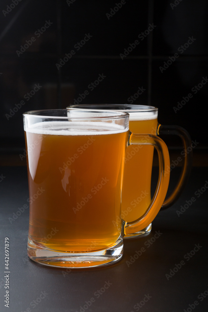 Glass of lager beer served on a black