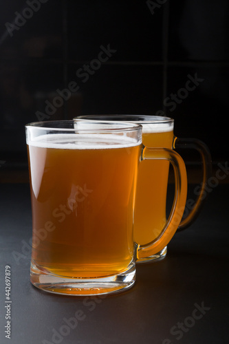 Glass of lager beer served on a black