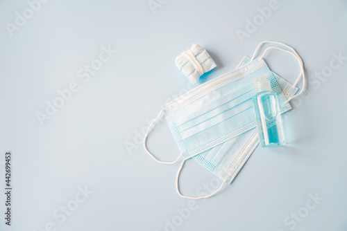 bottle of alcohol gel on blue disposable face mask and used mask, necessary for new normal lifestyle, awareness to protect ourself from corona virus concept