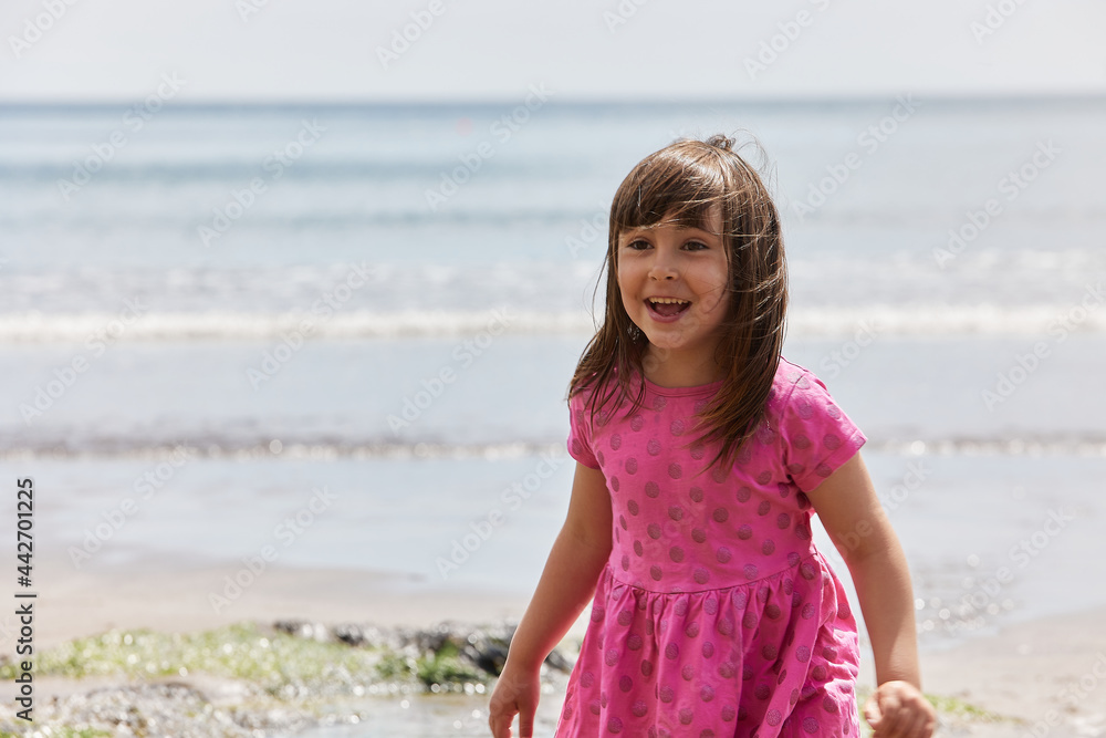 Adorable toddler girl playing with beach on white sand beach Adorable toddler girl playing with beach on white sand beach