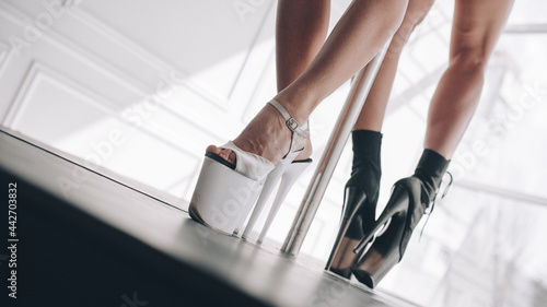 Girl's legs in high heels - strips in a light room (ID: 442703832)