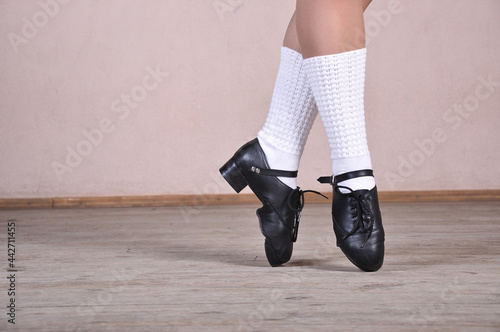 Valokuva Close-up of female legs in black leather shoes dancing national Irish dances