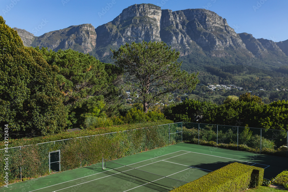 General view of tennis court in stunning countryside on sunny day