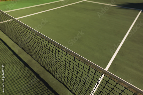 General view of tennis court and tennis net on sunny day
