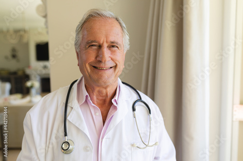Portrait of senior caucasian male doctor looking at camera and smiling