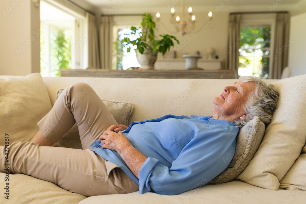 Senior caucasian woman lying on sofa with eyes closed Senior caucasian woman lying on sofa with eyes closed