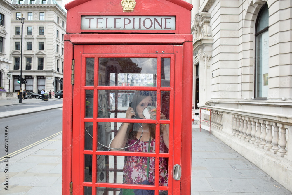 Sophisticated Lady Drinking Coffee in Red British Phone Booth