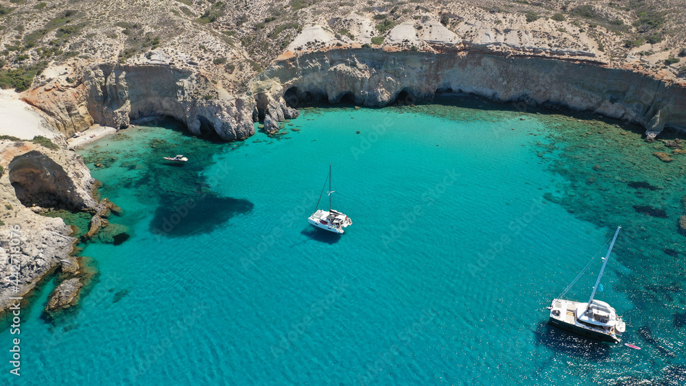 Aerial drone photo of beautiful scenic rocky cove and beach of Tsigrado with caves and crystal clear emerald sea, Milos island, Cyclades, Greece