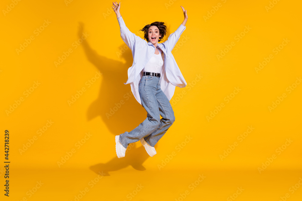 Full length body size photo of funny female student jumping up carefree childish isolated on bright yellow color background