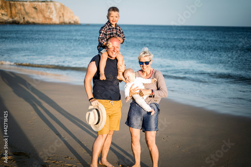 Obraz na płótnie The family with two small boys enjoying time on the beach in Portugal w salonie