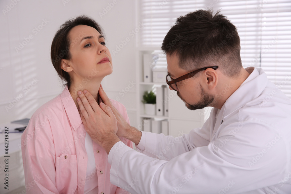 Doctor examining thyroid gland of patient in hospital Doctor examining thyroid gland of patient in hospital